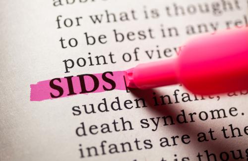 Page of a book with information about Sudden Infant Death Syndrome (SIDS). The definition of SIDS is being highlighted pink.