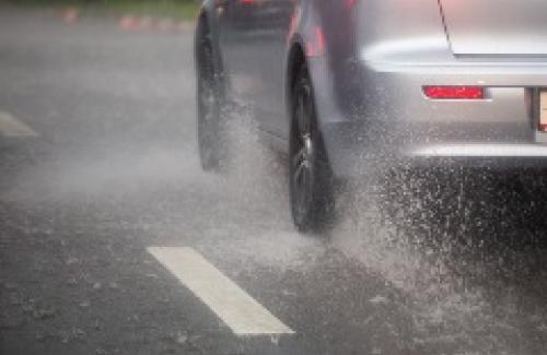 Car driving through rain on road (getty images)
