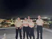 Photo of four explorers standing on a roof at night