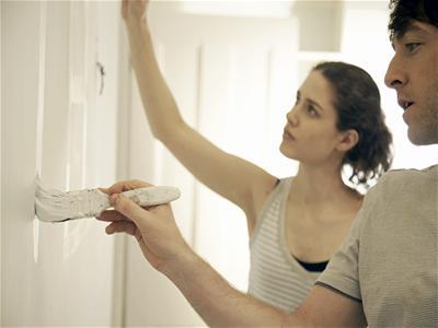 Couple painting new apartment